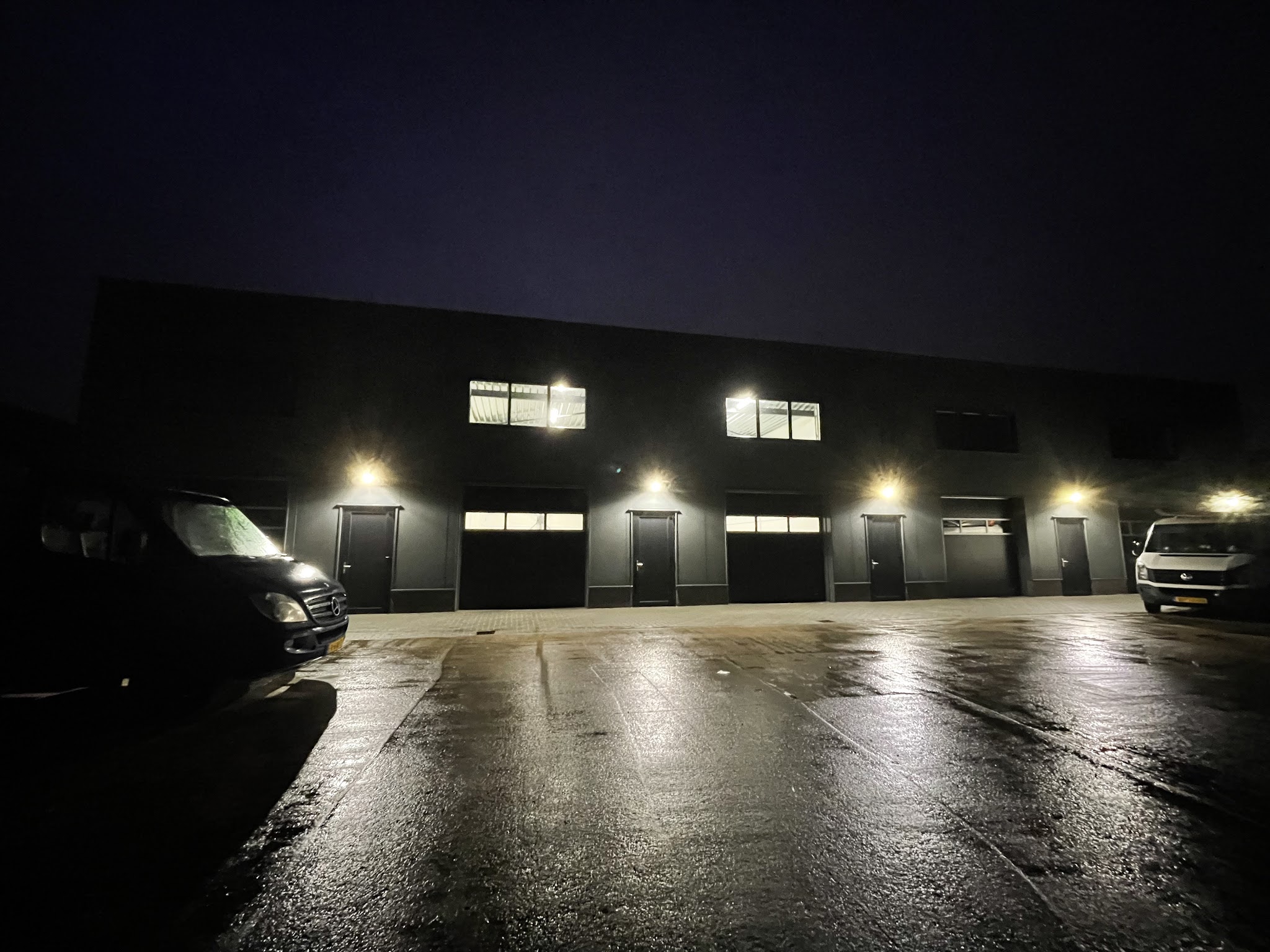 Bedrijfsunits in het donker met verlichting aan de gevel